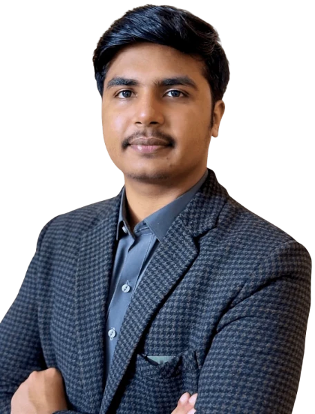 Zain Ismail in a checkered suit and grey shirt standing confidently against a green background.