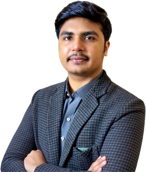 Zain Ismail in a checkered suit and grey shirt standing confidently against a green background.